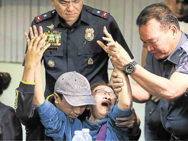 Melinda Gonzalgo is inconsolable upon coming face to face with hit-and-run suspect Alvin San Pablo (upper photo) at the QCPD headquarters on Tuesday. —LYN RILLON