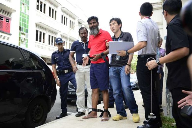 Rasheed Muhammad (in red) being escorted by the police at Rowell Road, on June 19, 2014. STRAITS TIMES FILE PHOTO