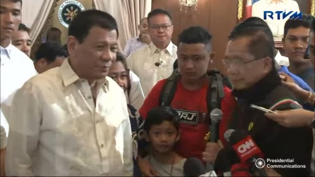 President Rodrigo Duterte (left) and Presidential peace adviser Jesus Dureza (right) with 8 year old Rexon Romoc and his parents Nora and Elmer. SCREENGRAB FROM RTVMALACANANG