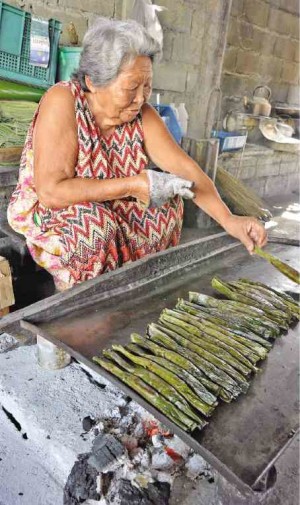 Nanay Patring, the oldest and most successful “tupig” maker of Mangatarem town in Pangasinan, cooks some of the hundreds of tupig she produces in a day in her shop in front of her house in the village of Umangan. —RAY ZAMBRANO