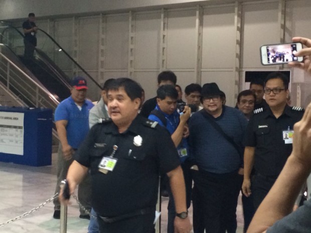 Wally Sombero is escorted by cops upon his arrival at the Ninoy Aquino International Airport. JEANNETTE ANDRADE/PHILIPPINE DAILY INQUIRER