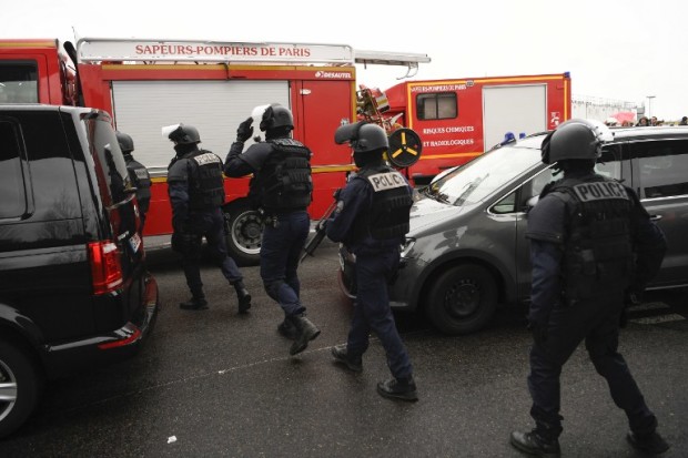 French policemen and firefighters secure the area at Paris' Orly airport on March 18, 2017 following the shooting of a man by French security forces. Security forces at Paris' Orly airport shot dead a man who took a weapon from a soldier, the interior ministry said. Witnesses said the airport was evacuated following the shooting at around 8:30am (0730GMT). The man fled into a shop at the airport before he was shot dead, an interior ministry spokesman told AFP. He said there were no people were wounded in the incident.  / AFP PHOTO / CHRISTOPHE SIMON
