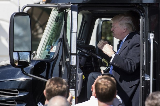 US President Donald Trump sits in the drivers seat of a semi-truck as he welcomes truckers and CEOs to the White House in Washington, DC, March 23, 2017, to discuss healthcare. / AFP PHOTO / JIM WATSON
