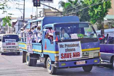 Government officials and workers in the Negros provinces join a caravan to drum up support for the retention of a unified region.  —RICHARD MALIHAN/CONTRIBUTOR
