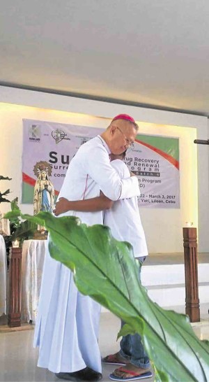 SPIRITUAL ASPECTCebu Archbishop Jose Palma embraces a another enrolee of the Surrender to God program in Barangay Yati, Liloan, Cebu.