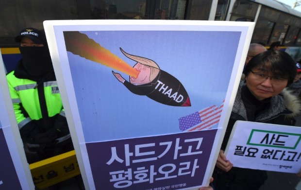 South Korean protesters hold placards showing a caricature of US President Donald Trump during a rally against the planned deployment of the US-built Terminal High Altitude Area Defense (THAAD) anti-ballistic missile system, outside the Defence Ministry in Seoul on February 28, 2017. Residents living near a South Korean golf course on February 28 sued to stop it becoming the site of a controversial US missile system loathed by Beijing, their lawyers said as Chinese media poured scorn on the plan. / AFP PHOTO / JUNG Yeon-Je