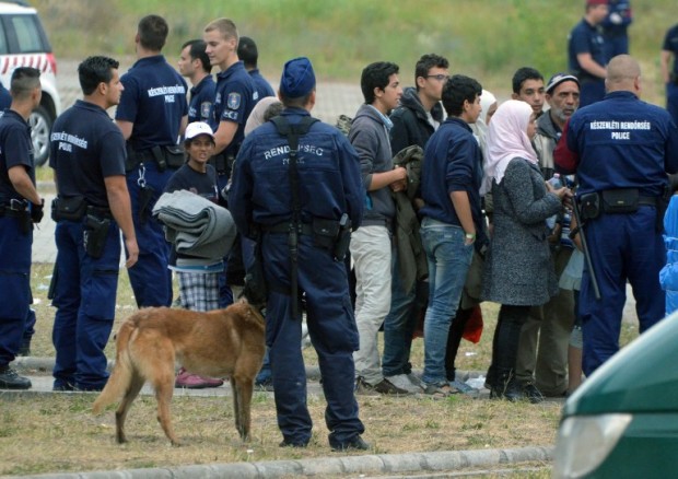 (FILES) This file photo taken on June 25, 2015 shows asylum-seekers waiting to board a bus at their temporary Hungarian home of Roszke border village at the Hungarian-Serbian border to transport them to a new refugee camp.   Hungary said on March 27, 2017 it was ready to begin detaining asylum-seekers in container camps on its southern border with Serbia after a recent passage of laws that have drawn criticism from rights groups and the UN / AFP PHOTO / CSABA SEGESVARI