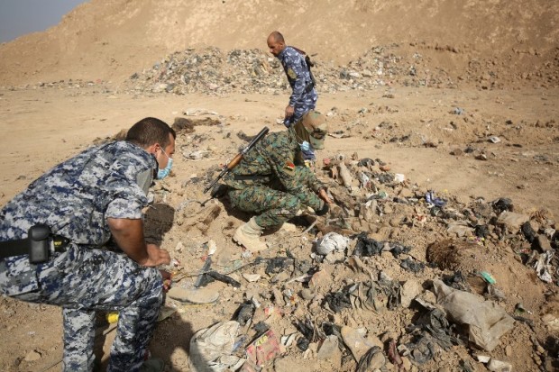 EDITORS NOTE: Graphic content / Member of the Iraqi forces check a mass grave they discovered in the Hamam al-Alil area on November 7, 2016 after they recaptured the area from Islamic State (IS) group jihadists during the ongoing operation to retake Mosul, the last IS-held Iraqi city. Iraqi investigators carried out an initial examination of a mass grave site discovered in an area south of Mosul that was recently retaken from the Islamic State group.  / AFP PHOTO / AHMAD AL-RUBAYE
