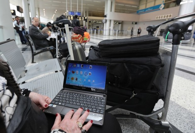 A Syrian woman travelling to the United States through Amman opens her laptop before checking in at Beirut international airport on March 22,2017. Hours after the US government warned that extremists plan to target passenger jets with bombs hidden in electronic devices, and banned carrying them in cabins on flights from 10 airports in eight countries in the Middle East and North Africa, Britain tightened airline security on flights from the same region, banning laptops and tablet computers from the plane cabin. / AFP PHOTO / ANWAR AMRO