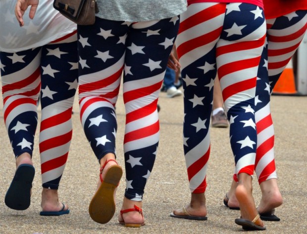 Four young women wear US flag leggings marking the Independence Day as they walk on Pennsylvania Avenue in Washington, DC on July 4, 2015. / AFP PHOTO / MLADEN ANTONOV