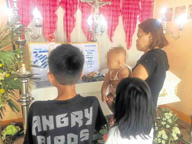 A relative and three of Michelle Mergillano’s children view her remains on Tuesday. —Jodee A. agoncillo