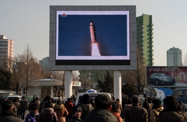 This photo taken on February 13, 2017 shows people in Pyongyang watching a public broadcast about the launch of a surface-to-surface medium long-range ballistic missile Pukguksong-2 at an undisclosed location on February 12. The UN Security Council on February 13 unanimously condemned North Korea's latest ballistic missile test as US President Donald Trump vowed to deliver a strong response to the provocation. / AFP PHOTO / KIM Won-Jin