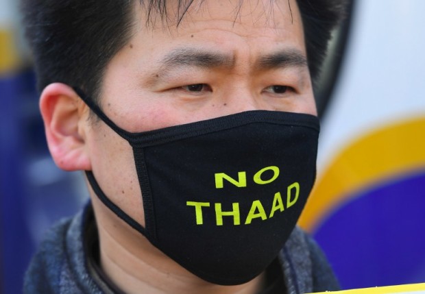 A South Korean protester wears a black mask reading "No THAAD" during a rally against the planned deployment of the US-built Terminal High Altitude Area Defense (THAAD) anti-ballistic missile system, outside the Defence Ministry in Seoul on February 28, 2017. Residents living near a South Korean golf course on February 28 sued to stop it becoming the site of a controversial US missile system loathed by Beijing, their lawyers said as Chinese media poured scorn on the plan. / AFP PHOTO / JUNG Yeon-Je