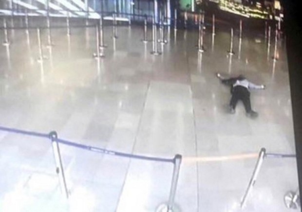 A picture taken from the screen of a monitor on March 18, 2017 shows a man lying on the ground  of a terminal building at Paris' Orly airport after he was shot by French security forces for taking a weapon from a soldier. Security forces at Paris' Orly airport shot dead a man who took a weapon from a soldier, the interior ministry said. Witnesses said the airport was evacuated following the shooting at around 8:30am (0730GMT). The man fled into a shop at the airport before he was shot dead, an interior ministry spokesman told AFP. He said there were no people were wounded in the incident.  / AFP PHOTO / - / ALTERNATIVE CROP