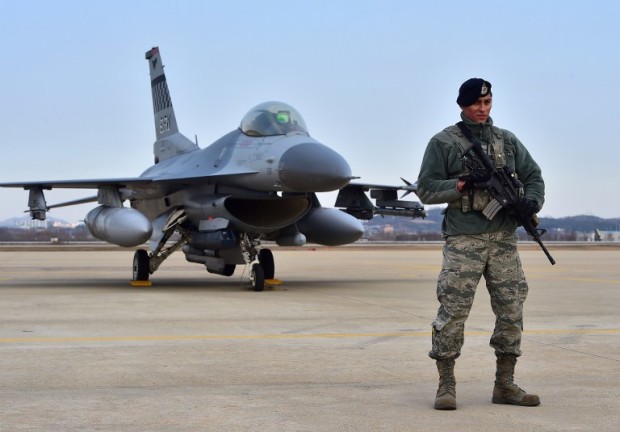 A US soldier (R) stands guard in front of a US F-16 fighter jet after a press briefing on the flight by a US B-52 Stratofortress over South Korea at the Osan Air Base in Pyeongtaek, south of Seoul, on January 10, 2016. The US sent a heavy bomber over South Korea on January 10 in a show of force as North Korean leader Kim Jong-Un insisted his country's latest nuclear test was carried out in self-defence. AFP PHOTO / JUNG YEON-JE / AFP PHOTO / JUNG YEON-JE
