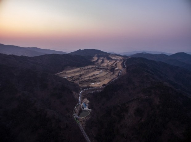 An aerial view shows a golf course used as the site of a recently installed anti Terminal High Altitude Area Defense (THAAD) system, in Seongju on March 18, 2017. South Korean retail giant Lotte agreed to provide land to host a controversial US missile defence system loathed by Beijing, Seoul's defence ministry said. The plan by Washington and Seoul to install the Terminal High Altitude Area Defense (THAAD) system in response to threats from nuclear-armed North Korea has angered Beijing, which fears it will undermine its own ballistic capabilities. / AFP PHOTO / Ed JONES