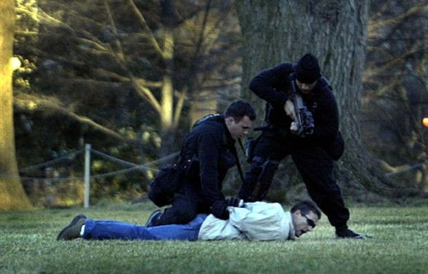 US Secrect Service Emergency Response Team officers take a man into custody moments after he jumped the White House fence on the North Lawn of the presidential mansion 25 February 2004 in Washington, DC.    AFP PHOTO / TIM SLOAN / AFP PHOTO / TIM SLOAN