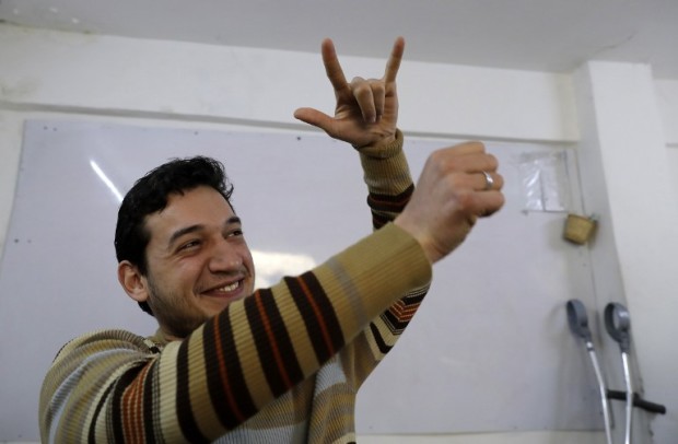 Ryad Hommos, a 21-year-old deaf Syrian man expresses that a plane is dropping bombs using sign language during a class for deaf people at the EEMAA association, an NGO centre for the deaf in Damascus' Midan district on March 7, 2016. Ryad and Bisher who are both deaf are working to create special sign language characters so thousands of Syrians like them can talk about the war that has ravaged their country for the past six years. Photo by AFP.