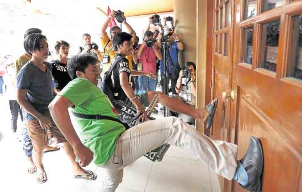 Angry protesters kick the door of the Dole office in Intramuros. —MARIANNE BERMUDEZ