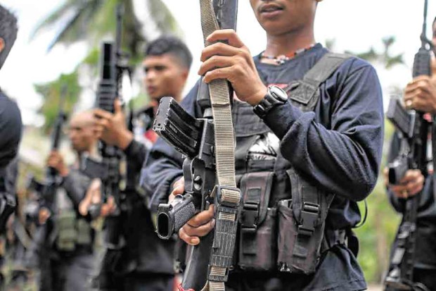 New People’s Army rebels stand in attention at ceremonies for the release of militiamen Rene Doller and Carl Mark Nucos on March 25. —KARLOS MANLUPIG