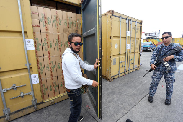 SMUGGLE CIGARETTES/MARCH 7, 2017: A coast guard personel (right) stand guard to the sized by the Bureau of Customs the alledge smuggled Mighty cigarettes in two 20 footer container vans at pier 4.(JUNJIE MENDOZA)