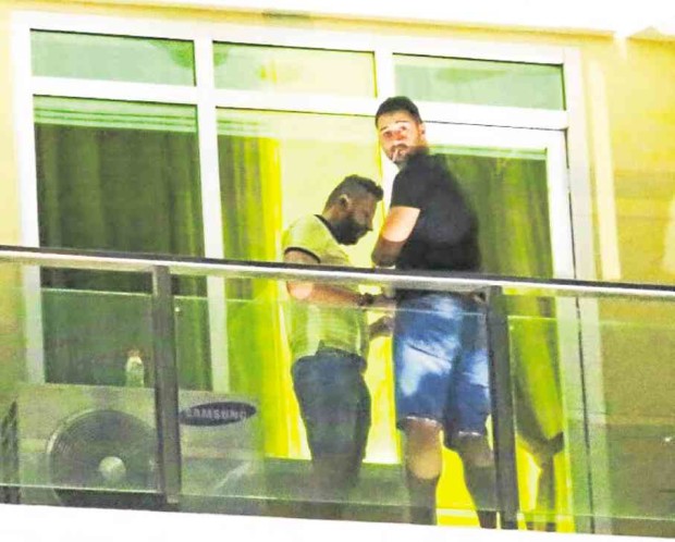 Two of the three Romanians arrested for hacking ATMs in Cebu City at the balcony of their condominium unit —JUNJIE MENDOZA/CEBU DAILY NEWS