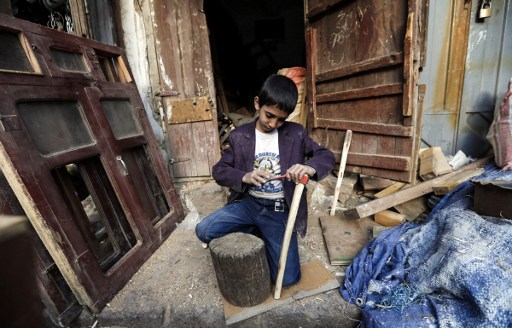 A Yemeni child sharpens an axe at a woodworking shop in a market in Sanaa's old city on January 24, 2017. The devastating conflict that escalated in March 2015 with a military intervention by the Saudi-led coalition to support the government, has resulted in the deterioration of humanitarian and health conditions for some 26 million Yemenis, depriving two thirds of the population of medical care while it made food scarce. According to the UN, over 7,400 people have been killed, including 1,400 children. AFP FILE PHOTO