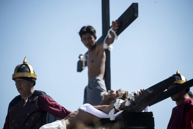 Willy Salvador (bottom), 60, hangs from a cross as part of his penitence during a reenactment of the crucifixion of Jesus Christ for Good Friday celebrations ahead of Easter in the village of San Juan, Pampanga, north of Manila on April 14, 2017. Devotees in the fervently Catholic Philippines nailed themselves to crosses and whipped their backs in extreme acts of faith that have become an annual tourist attraction. 