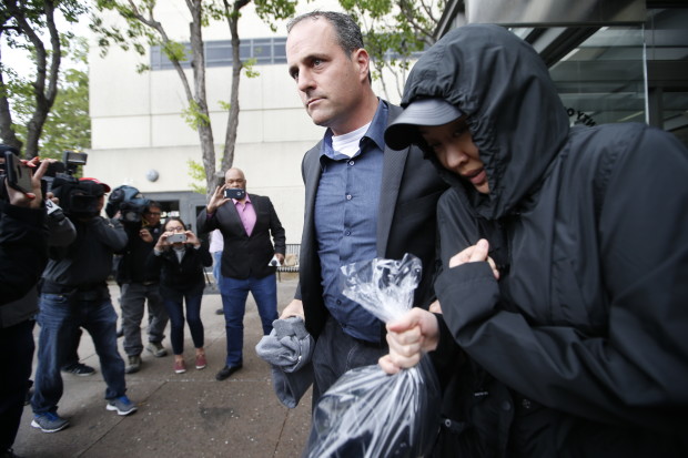 Tiffany Li, right, leaves with a bodyguard from San Mateo County Jail after posting an unprecedented $35 million bail raised by friends, family and business associates with ties to China on Thursday, April 6, 2017, in Redwood City, Calif. (AP Photo/Tony Avelar)