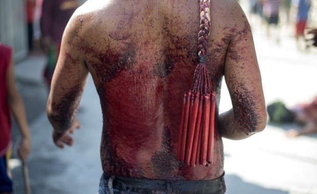 Participants whip their bloodied backs with bamboo as part of their penitence during the re-enactment of the crucifixion of Jesus Christ for Good Friday celebrations ahead of Easter in the village of San Juan, Pampanga, north of Manila on April 14, 2017. Devotees in the fervently Catholic Philippines nailed themselves to crosses and whipped their backs in extreme acts of faith that have become an annual tourist attraction. / AFP PHOTO / NOEL CELIS