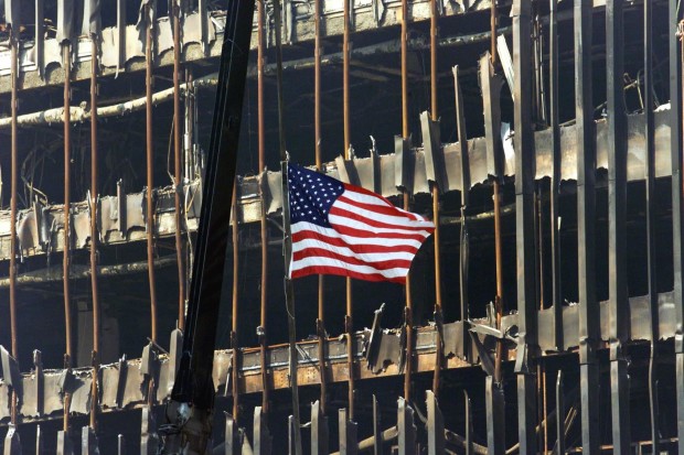 An American Flag hangs from a crane as workers clear the remains of the destroyed World Trade Center 22 September 2001 in New York. AFP FILE PHOTO