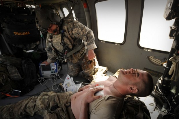This file photo taken on March 25, 2011 shows a US army flight medic Sergeant Bobby Dorris from Company C, 1st Battalion, 52nd Aviation Regiment, MEDEVAC team treating a US Army soldier (bottom) for an unspecified complaint on their Blackhawk helicopter in southern Afghanistan. It was first used by the armies of the Roman Empire. Centuries later, the tourniquet is buying casualties in Afghanistan what they need most -- time -- as surgeons adapt battlefield medical procedures to the grinding conflict. / AFP PHOTO / Peter PARKS