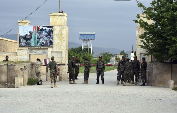 Afghan soldiers stand guard at the gate of a military compound after an attack by gunmen in Mazar-e- Sharif province north of kabul, Afghanistan, Friday, April 21, 2017. Gunmen wearing army uniforms stormed a military compound in the Balkh province, killing at least eight soldiers and wounding 11 others, an Afghan government official said Friday. (AP Photo/Mirwais Najand)
