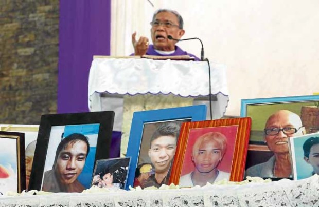 PORTRAIT OF VICTIMS Novaliches Bishop Antonio Tobias celebrates Mass in SantoNiño Parish Church, Bagong Silang, Caloocan City, amid portraits of victims of extrajudicial killings