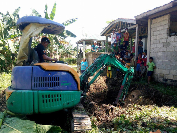 A soldier mans a backhoe to dig a gravesite at the public cemetery for the three Abu Sayyaf members killed during the clash with government troops in Clarin town, Bohol, on Saturday.