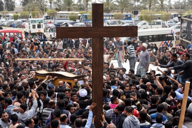 Mourners carry a large cross and the coffin of one of the victims of the blast at the Coptic Christian Saint Mark's church in Alexandria the previous day during a funeral procession at the Monastery of Marmina in the city of Borg El-Arab, east of Alexandria on April 10, 2017. Egypt prepared to impose a state of emergency after jihadist bombings killed dozens at two churches in the deadliest attacks in recent memory on the country's Coptic Christian minority. / AFP PHOTO / MOHAMED EL-SHAHED