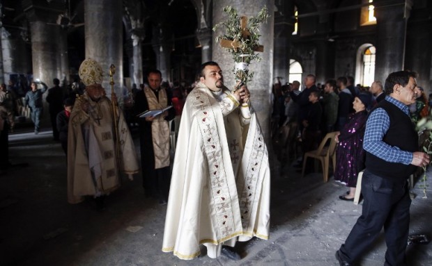 A Syrian Catholic clergyman participates in the Palm Sunday procession followed by the Archbishop of Mosul, Yohanna Petros Mouche, as Iraqi Christian residents of Qaraqosh (also known as Hamdaniya) attend mass on April 9, 2017, some 30 kilometres east of Mosul. Qaraqosh, with an overwhelmingly Christian population of around 50,000 before the jihadists took over the area in August 2014, was the largest Christian town in Iraq. / AFP PHOTO / AHMAD GHARABLI