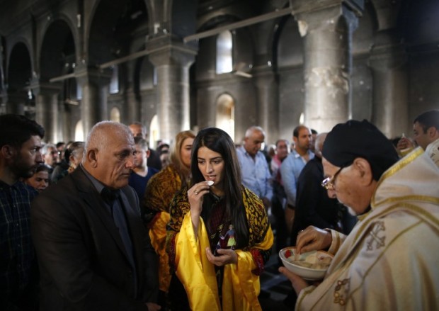 Iraqi Christian residents of Qaraqosh (also known as Hamdaniya), some 30 kilometres east of Mosul, attend the first Palm Sunday service at the heavily damaged Church of the Immaculate Conception on April 9, 2017, since Iraqi forces recaptured it from Islamic State (IS) group jihadists. Qaraqosh, with an overwhelmingly Christian population of around 50,000 before the jihadists took over the area in August 2014, was the largest Christian town in Iraq. / AFP PHOTO / AHMAD GHARABLI