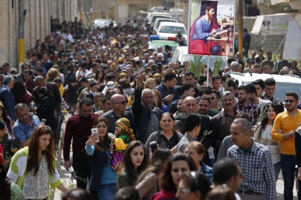 Iraqi Christian residents from Qaraqosh (also known as Hamdaniya), some 30 kilometres east of Mosul, take part in a parade on April 9, 2017, as Christians celebrate the first Palm Sunday event in the town since Iraqi forces recaptured it from Islamic State (IS) group jihadists. Qaraqosh, with an overwhelmingly Christian population of around 50,000 before the jihadists took over the area in August 2014, was the largest Christian town in Iraq. / AFP PHOTO / AHMAD GHARABLI