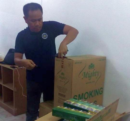 Joenel Pogoy opens box of Mighty cigarettes in Tacloban warehouse - 7 April 2017