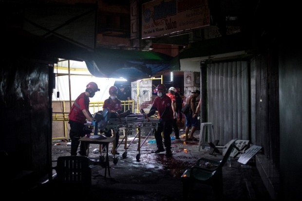 Rescue workers attend to a wounded man on a stretcher in an alley in Manila on April 28, 2017, after a homemade pipe bomb exploded.  Fourteen people were wounded in a pipe bomb blast, Philippine police said, but authorities dismissed any link to an Asian leaders' meeting under way in the capital. / AFP PHOTO / NOEL CELIS