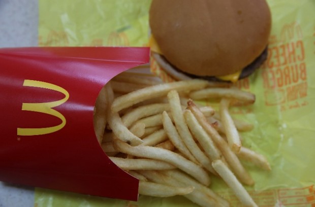 NOVATO, CA - DECEMBER 08: In this photo illustration, a McDonald's cheeseburger and fries are displayed on a table at a McDonald's restaurant on December 8, 2014 in Novato, California. McDonald's reported a worse than expected decline in November global same-restaurant sales. (Photo Illustration by Justin Sullivan/Getty Images/AFP