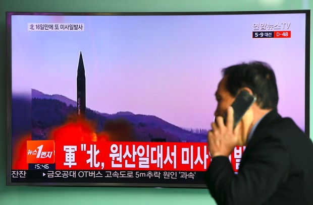 A man walks past a television screen showing file footage of a North Korean missile launch, at a railway station in Seoul on March 22, 2017. A new North Korean missile test failed on March 22, the South and US said, two weeks after Pyongyang launched four rockets in what it called a drill for an attack on American bases in Japan. / AFP PHOTO / JUNG Yeon-Je
