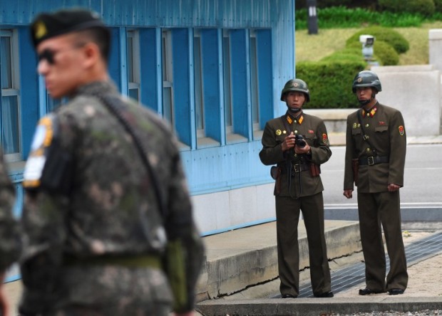 North Korean soldiers (R) look at the South side while US Vice President Mike Pence (not pictured) visits the truce village of Panmunjom in the Demilitarized Zone (DMZ) on the border between North and South Korea on April 17, 2017. Pence arrived at the gateway to the Demilitarised Zone dividing the two Koreas, in a show of US resolve a day after North Korea failed in its attempt to test another missile. / AFP PHOTO / JUNG Yeon-Je