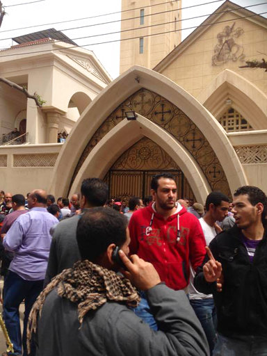 Relatives and onlookers gather outside a church after a bomb attack in the Nile Delta town of Tanta, Egypt, Sunday, April 9, 2017. The attack took place on Palm Sunday, the start of the Holy Week leading up to Easter, when the church in the Nile Delta town of Tanta was packed with worshippers. (AP Photo/Ahmed Hatem)