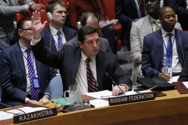 Russian Deputy Permanent Representative to the United Nations Vladimir Safronkov holds up his hand as he votes against a Draft resolution that condemns the reported use of chemical weapons in Syria at the Security Council on April 12, 2017 at UN Headquarters in New York.  The United Nations peace envoy for Syria on Wednesday urged the United States and Russia to agree on a way forward to end the war in Syria and pave the way for a "real negotiation." Special envoy Staffan de Mistura told the UN Security Council that he was ready to convene a new round of talks in May but that US-Russian cooperation was needed.  / AFP PHOTO / KENA BETANCUR