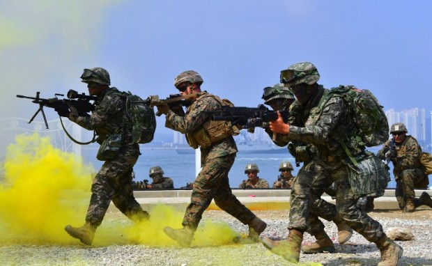 South Korean and US marines move to a position during a re-enactment of the Incheon landing to mark the 66th anniversary of the start of Operation Chromite, the battle that turned the tide in the Korean War, in the western port city of Incheon on September 9, 2016.  South Korea marked the 66th anniversary of the daring Incheon Landing which was led by US General Douglas MacArthur and led two weeks later to the recapture of Seoul from North Korean invaders during the Korean War. North Korea has conducted a fifth nuclear test, its most powerful to date, South Korea's President Park Geun-Hye said on September 9, condemning the move as an act of "self-destruction" that would deepen its isolation. / AFP PHOTO / JUNG YEON-JE