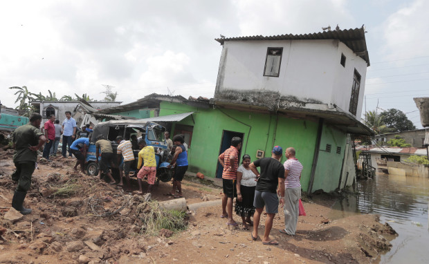 Sri Lankans affected by a garbage dump collapse salvage their belongings in Meetotamulla, on the outskirts of Colombo, Sri Lanka, Saturday, April 15, 2017. A part of the garbage dump that had been used in recent years to dump the waste from capital Colombo collapsed destroying houses, according to local media reports. (AP Photo/Eranga Jayawardena)