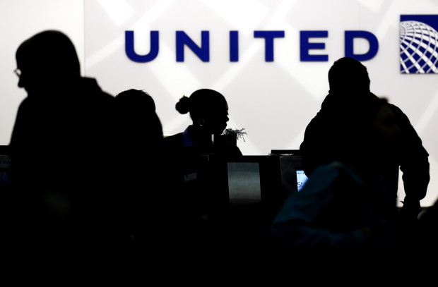 In this Saturday, Dec. 21, 2013, file photo, travelers check in at the United Airlines ticket counter at Terminal 1 in O'Hare International Airport in Chicago. After a man is dragged off a United Express flight on Sunday, April 9, 2017, United Airlines becomes the butt of jokes online and on late-night TV. Travel and public-relations experts say United has fumbled the situation from the start, but it’s impossible to know if the damage is temporary or lasting. Air travelers are drawn to the cheapest price no matter the name on the plane. (AP Photo/Nam Y. Huh, File)