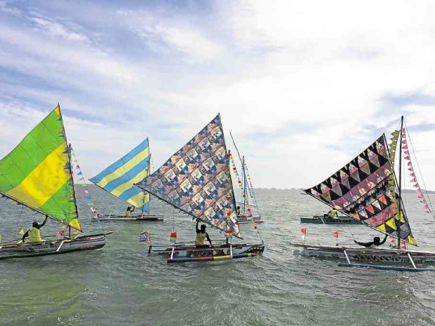 “Paraw,” the indigenous monosail fishing vessels of Alaminos City and its neighboring coastal towns, sail at the Lu cap Bay during the launching of Paraw Festival on March 28. —YOLANDA SOTELO
